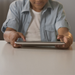 Autistischer Junge im Schulalter nutzt digitale Medien: Autismus und Medienkonsum können eine Chance sein.